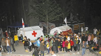 4月21日，中国红十字会工作人员在四川芦山县为受灾群众发放药品、食品饮料等。新华社记者 何俊昌 摄