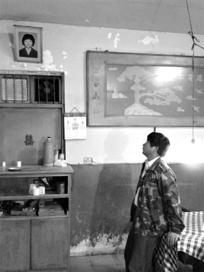 5月5日，萧山衙前镇吟龙村，徐祥华看着妻子的遗像，说生活又被打乱。18年前，徐妻跑出租车遇害，去年该案发现新的线索。新京报记者 刘刚 摄