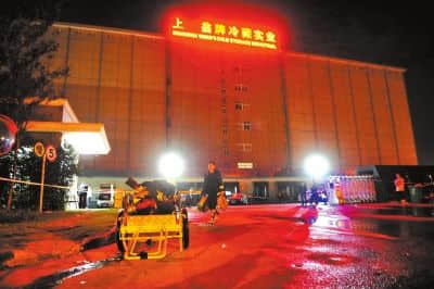 出事的翁牌冷藏实业有限公司大门口，消防官兵正在清理救援使用的水带。